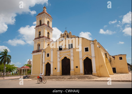 Man riding bicycle in front of Iglesia Mayor de San Juan Bautista church in Remedios, Cuba. Stock Photo
