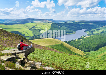 Hiker sat on Whinstone Lee Tor Derwent moor above Ladybower reservoir Derbyshire Peak District national park Derbyshire England Stock Photo