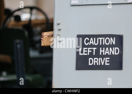 Sign on the back of an old Landrover warning following motorists that it is left-hand drive. Stock Photo