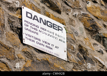 Sign warning visitors that a monument is unsafe, and advising them that they view at their own risk. Stock Photo
