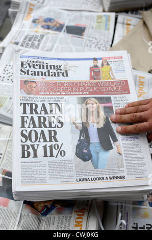 A hand grabbing a copy of the London Evening Standard newspaper Stock Photo