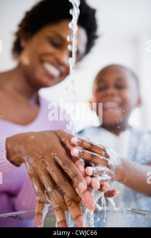 Black mother and son washing hands Stock Photo