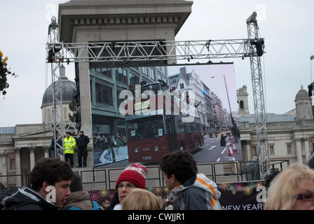 Open topped bus on large display screen at the base of Nelson's Column in Trafalgar Square showing the New Years Day parade Stock Photo