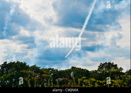 Two planes performing aerial aerobatics with a smoke trails against a moody sky backdrop. Stock Photo