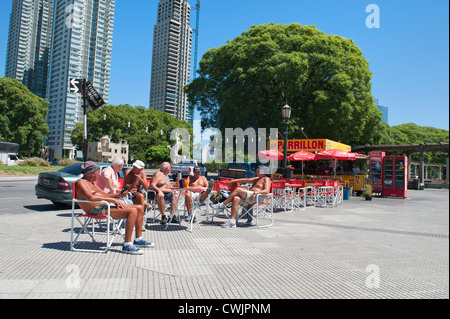 Men resting beside a kiosk, Puerto Madero district, Buenos Aires Stock Photo