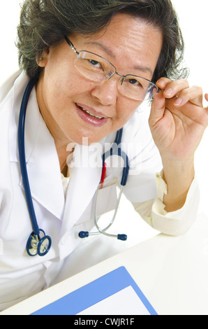 Asian senior female doctor adjusting her spectacles Stock Photo