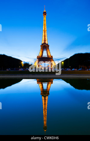 Paris Eiffel tower illuminated at night from the Champs de Mars gardens reflected in a pool Paris France EU Europe