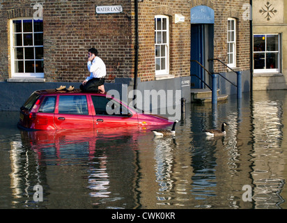 A stranded motorist phones for help from the top of his car  as the high tide causes flooding along the River Thames - Richmond Stock Photo