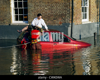 Fireman rescues a stranded motorist as the high tide causes flooding along the River Thames - Richmond Stock Photo