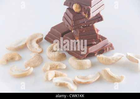 Blocks of chocolate with almond and cashew nuts against white background Stock Photo
