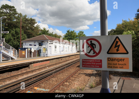 Electrified railway tracks with danger sign warning passengers not to cross track on Ashford to London line England UK Britain Stock Photo
