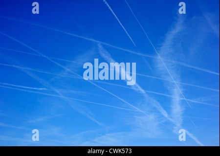 Blue sky filled with many aviation vapour trails from aircrafts in heavy air traffic Stock Photo