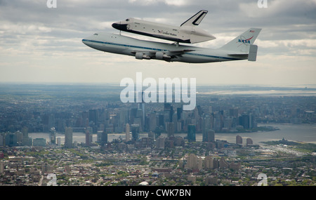 Space shuttle Enterprise, mounted atop a NASA 747 Shuttle Carrier Aircraft is seen as it flies over the Manhattan Skyline with Freedom Tower in the background April 27, 2012 in New York. Enterprise was the first shuttle orbiter built for NASA performing test flights in the atmosphere and was incapable of spaceflight. Stock Photo