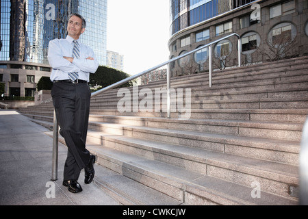 Hispanic businessman standing outdoors with arms crossed Stock Photo