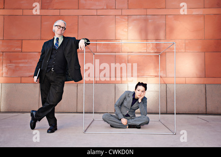 Businessman standing next to co-worker in box Stock Photo