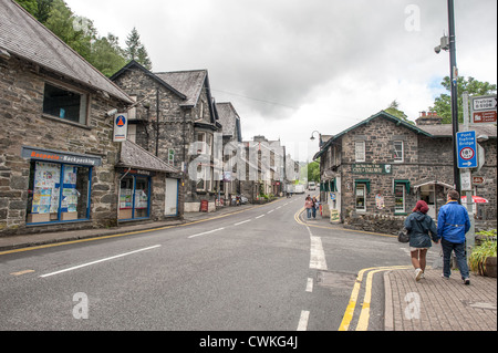 BETWS-Y-COED, Wales, United Kingdom — A picturesque street in the heart of Betws-y-Coed showcases the village's charming character, with traditional stone buildings lining the thoroughfare. This quaint Welsh village, nestled in the Conwy Valley within Snowdonia National Park, serves as a popular gateway for tourists exploring the rugged beauty of North Wales. Stock Photo