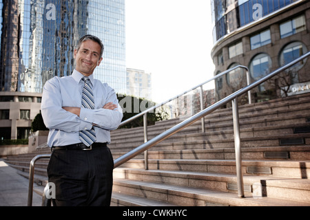 Hispanic businessman standing outdoors with arms crossed Stock Photo