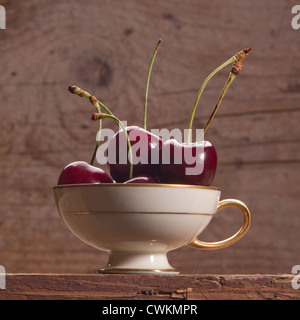 some cherries in a little antique cup Stock Photo