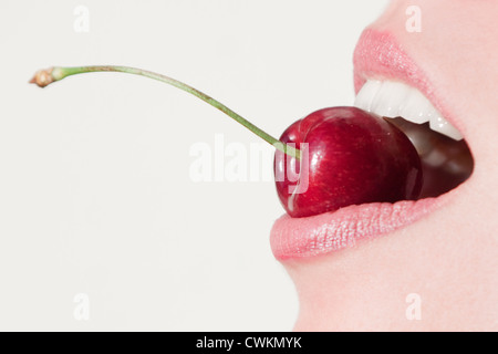 woman mouth close up eating a cherry