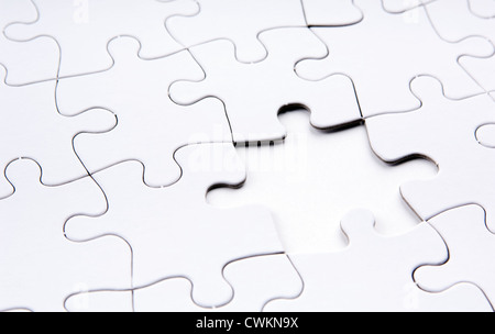 Jigsaw puzzle in white with a missing piece Stock Photo