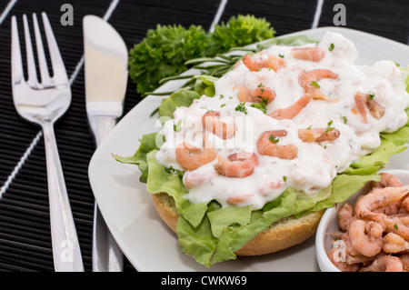 Shrimp-Salad on a roll against black background Stock Photo