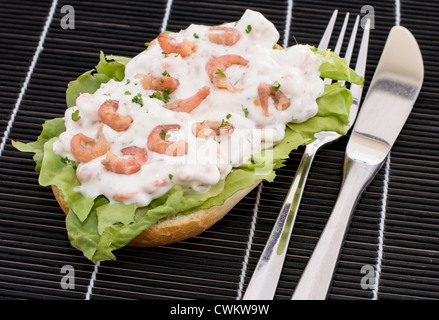 Shrimp-Salad on a roll against black background Stock Photo
