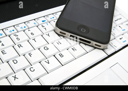 smart phone on laptop keyboard background Stock Photo