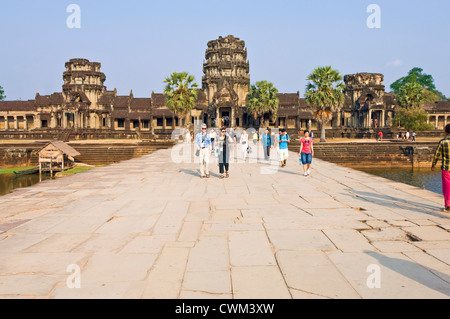 Horizontal view of tourists walking along the main causeway at the Western Gopura, the entrance into Angkor Wat. Stock Photo
