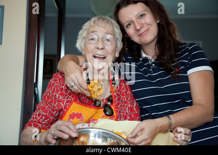 Polish grandma and granddaughter celebrate after cleaning a bowel of mushrooms for the evening meal. Zawady Central Poland Stock Photo