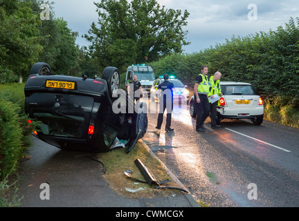 car accident where a car overturned at the side of the road in the United Kingdom Stock Photo