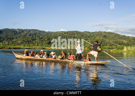 Malagasy people of ethnic Betsimisaraka crossing the river by canoe on apr 22, 2007 near Maroantsetra in eastern Madagascar Stock Photo