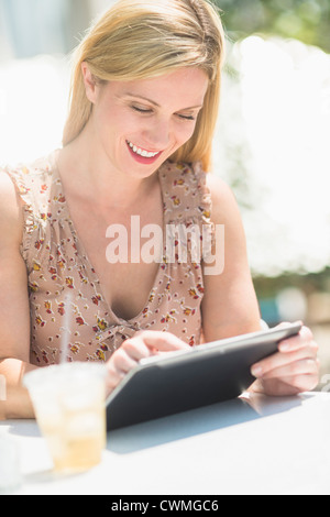 USA, New Jersey, Jersey City, Woman using tablet pc at outdoor cafe table Stock Photo