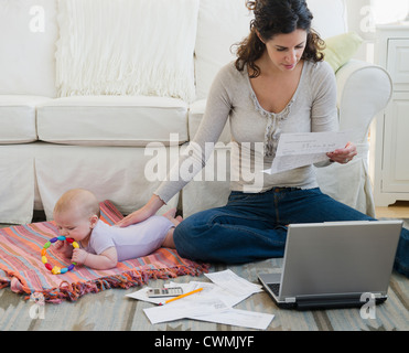 USA, New Jersey, Jersey City, Mother with baby boy (2-5 months) sorting home finances Stock Photo