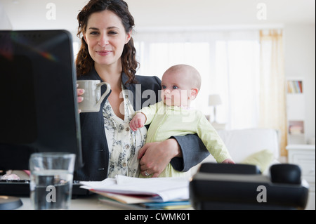 USA, New Jersey, Jersey City, Mother with baby boy (2-5 months) working from home Stock Photo