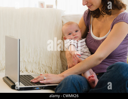 USA, New Jersey, Jersey City, Mother with baby boy (2-5 months) using laptop Stock Photo