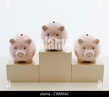 Three piggy banks in arranged on sports podium Stock Photo