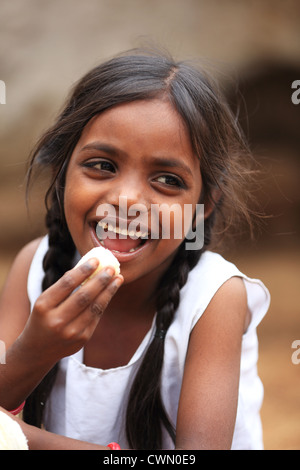 Young Indian rural girl eating a banana Andhra Pradesh South India Stock Photo