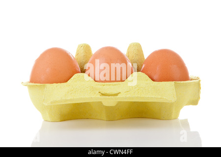 Chicken eggs in yellow carton box over white background Stock Photo