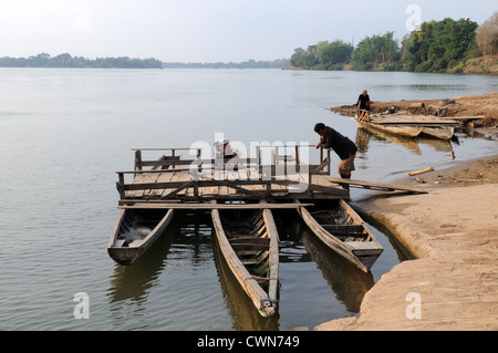Lao men waiting for passengers for their ferry boat on the Mekong River Don Khong Southern Laos Stock Photo