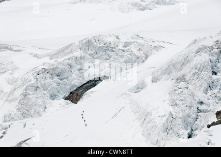 Alpine climbers traveling on a glacier in the Swiss alps Stock Photo