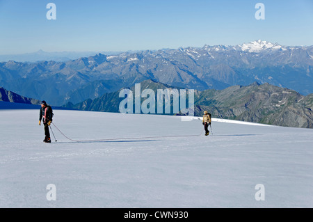 Alpine climbers traveling on a glacier in the Swiss alps Stock Photo