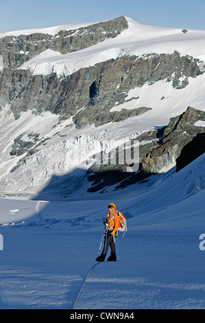 A climber traveling on a glacier in the Swiss alps Stock Photo