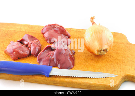 Fresh raw chicken liver lies on a wooden board next to the knife and onion Stock Photo