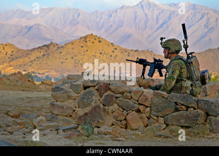 A US Army soldier provides security during a combat operation August 23, 2012 outside Combat Outpost Charkh, Logar province, Afghanistan. US Army paratroopers provided support while Afghan National Army soldiers searched houses for weapons caches. Stock Photo