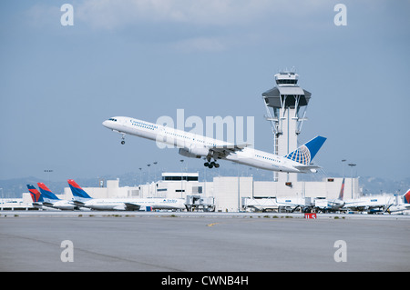 Continental airlines jet taking off past control tower at LAX Stock Photo