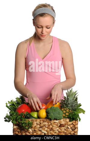 Beautiful young woman with basket of fruits and vegetables isolated over white background Stock Photo
