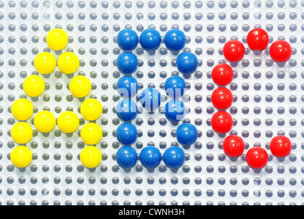 Fun and colorful pins from child board game used to write A,B,C in bright blue, yellow and red. Stock Photo