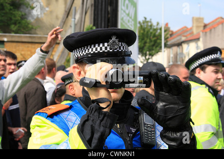 Metropolitan Police Forward Intelligence Team evidence gatherer films protesters at an EDL rally and UAF counter demonstration Stock Photo