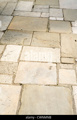 Old flagstone pavement of different size slabs laid in a random pattern Stock Photo