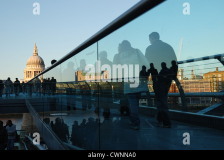 Crowds of commuters surging across the Millenium Bridge; St Paul's Cathedral in background. London, England. Stock Photo